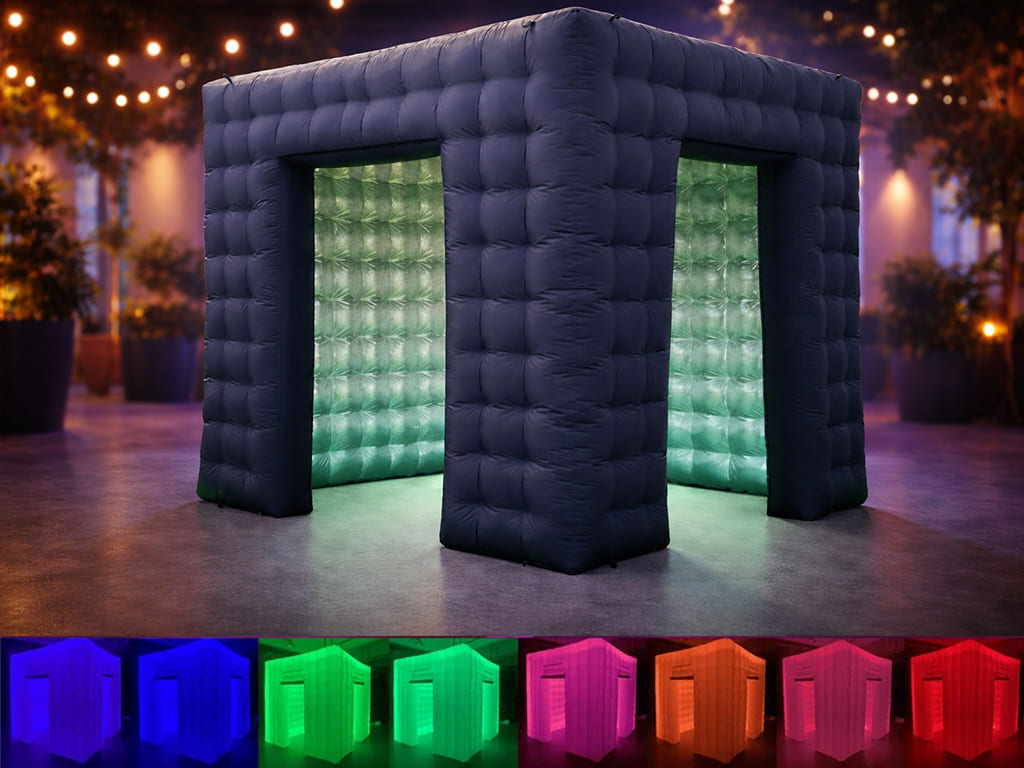 Black wireless speaker with colorful LED lights and two black wireless microphones on a dark surface.